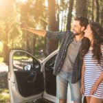 Happy couple exploring Albania with a Stir Rental car at a scenic spot